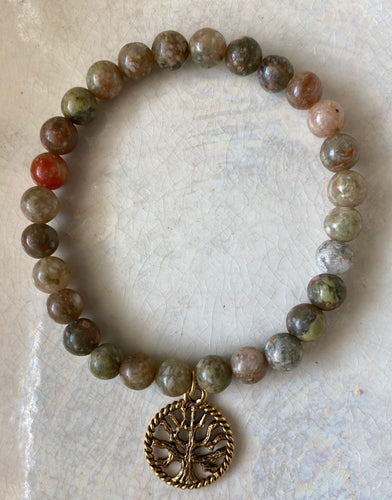 Add a Tree of Life charm symbolizing your ability for growth.  Standing strong, the Tree of Life symbolizes strength,  wisdom, beauty and protection. 